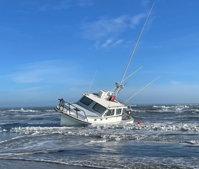 White vessel grounded on the beach.