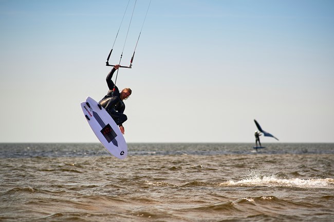 kite surfer on a board in the air above a wave