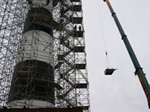 A crane lifts a piece of scaffolding that will surround the Bodie Island Lighthouse