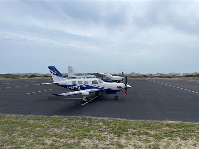 two airplanes on a paved airstrip
