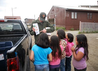 park ranger teaches children on the side of the road