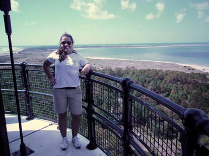 Jessica Vartanian on the gallery of the Cape Lookout Lighthouse with a view towards the point of Cape Lookout.