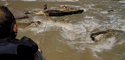 pulling a raft in a river rapid