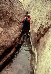 A hiker navigates through Burro Wash.