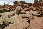 Visitors hike among black boulders in Capitol Reef National Park.