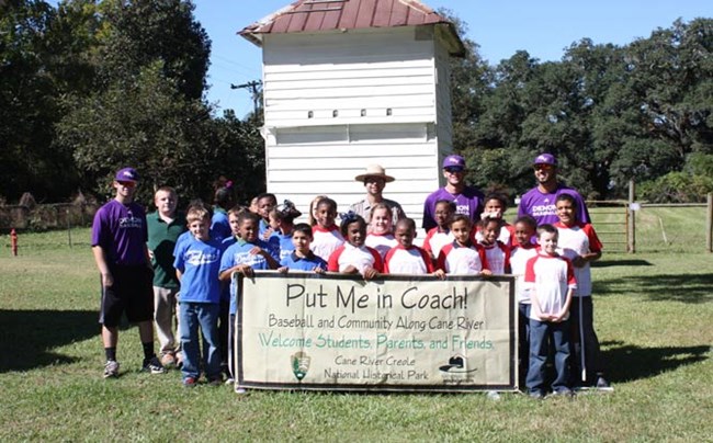 Group photograph of Cloutierville Elementary School students and Northwestern State University Baseball players before a baseball game at Magnolia Plantation