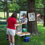 Ranger demonstrating how to make cheese from goat's milk.