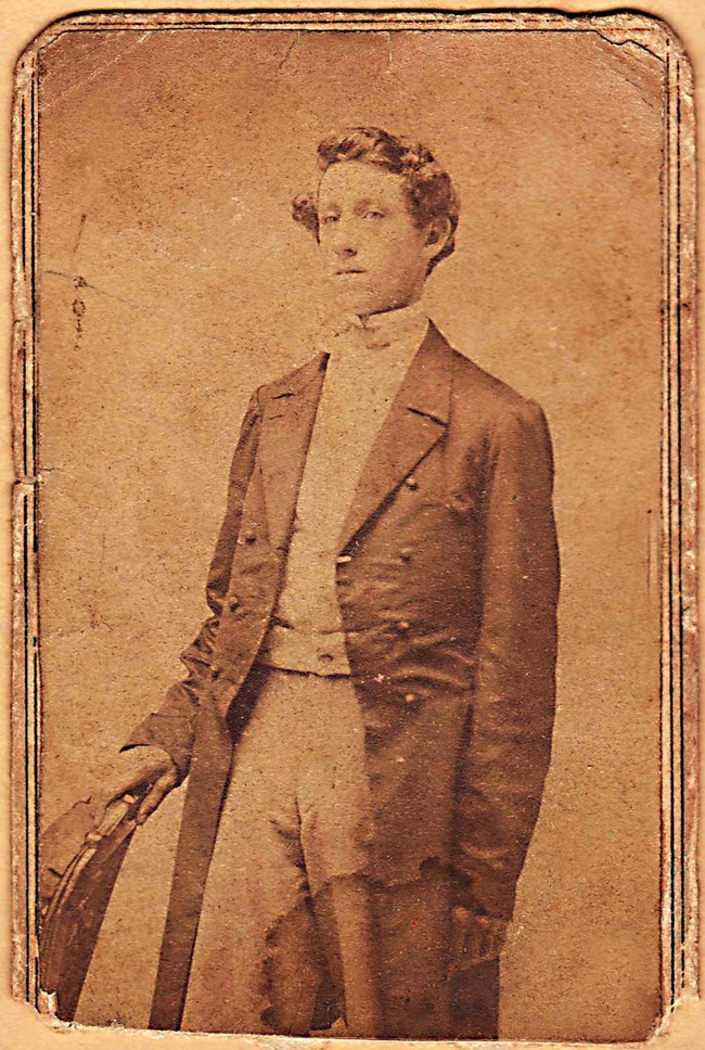 Sepia toned portrait of a young man named Elias Peck dressed in a coat