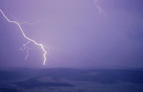 color photograph of lightning bolt striking mesa