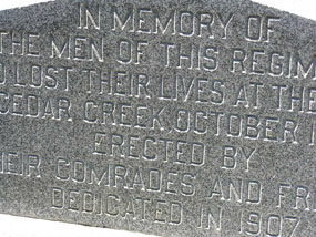 Closeup picture of part of a stone monument with block print engraving.