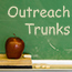 Green chalk board with "Outreach Trunks" written. Red apple on eraser in foreground.