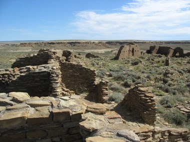 Remains of tan masonry walls overlooking a desert landscape.