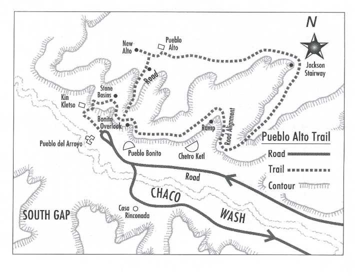 Black and white map of a loop trail named Pueblo Alto Trail. Solid lines indicate the road, with a dashed line showing the path of the trail. Numerous locations and features are identified via typed text on the map.