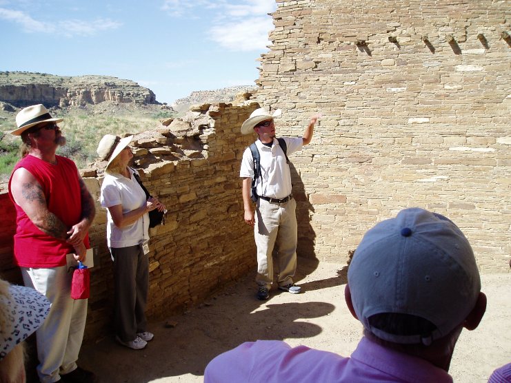 Photo of SCA volunteer Jeff Sisneros explaining detail of wall at Pueblo Bonito.