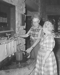 Man and woman dispensing mineral water