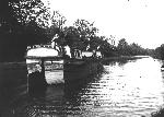 A woman steers a boat on the canal