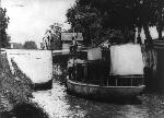 Boat on the canal below a house