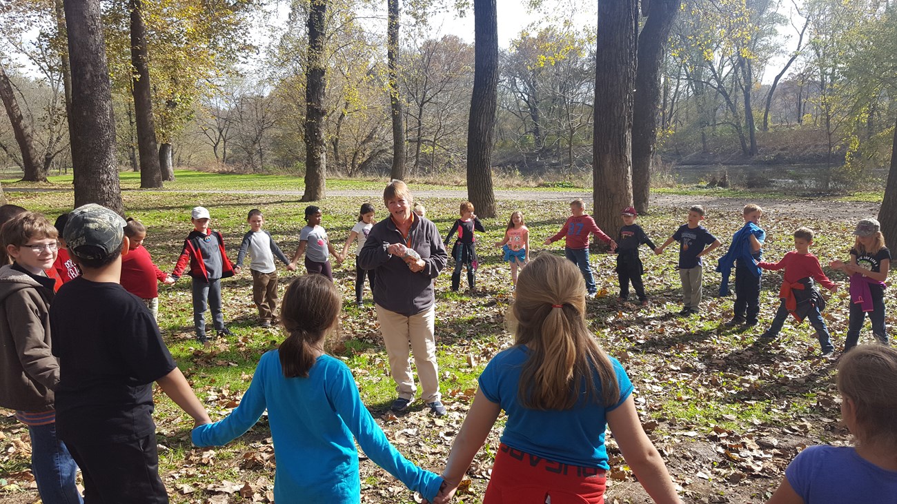 Canal Teacher and students enjoy an activity in the park on a sunny autumn day