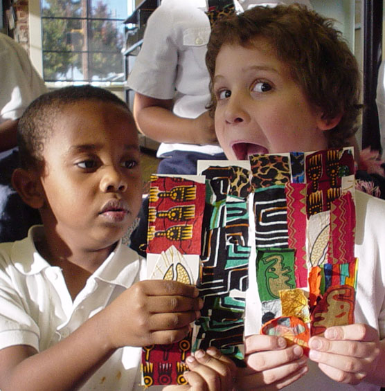Two children hold bookmarks they created. Two children hold bookmarks they created.