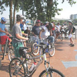 Park Ranger Julie Jackson talks to riders along the banks of the Arkansas River with downtown Little Rock in the background.
