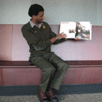 Park Ranger reads to children seated on the floor of the visitor center exhibit area.