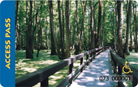 America the Beautiful Access pass with boardwalk through the woods.