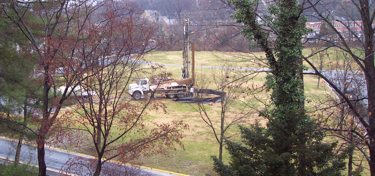 Well drilling truck in grassy field in front of Clara Barton National Historic Site.