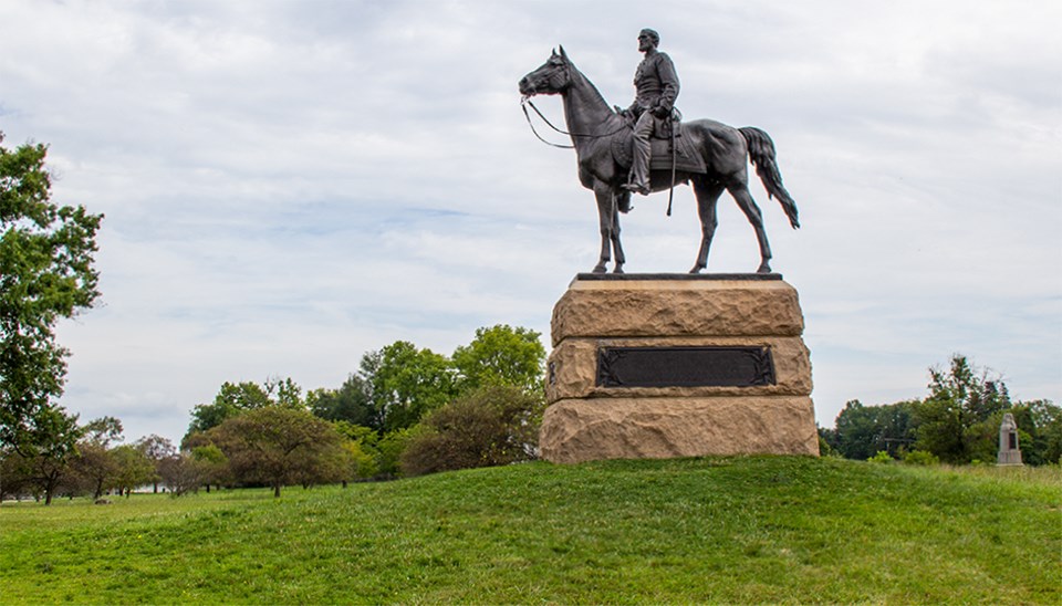 Civil War veterans gather around the large equestrian statue of General George Gordon Meade.