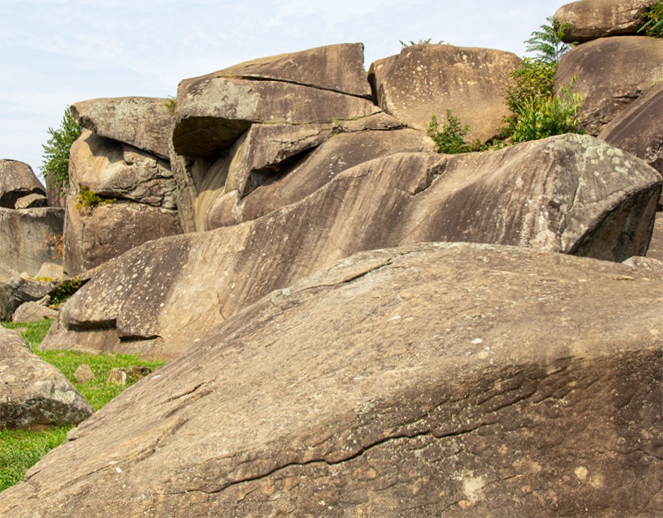 A Civil War sketch artist, Alfred Waud, sits atop a boulder in Devil's Den as he poses for a picture.