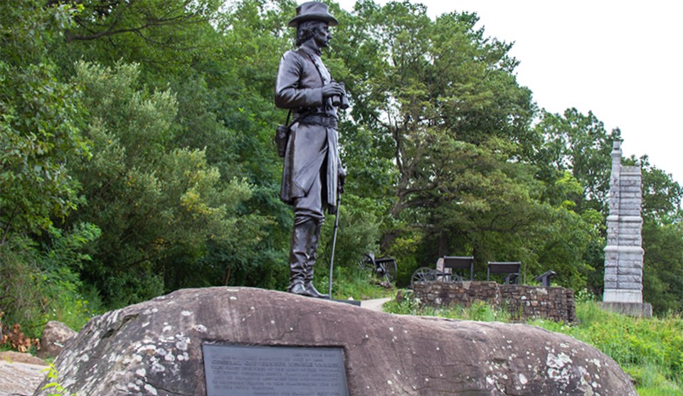 A group of Civil War veterans visit the statue to General Gouverneur Kemble Warren at the summit of Little Round Top.