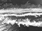 aerial view of breaking waves and overwash on sandy beach
