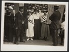 Police officers arresting women dressed in white and wearing sashes.