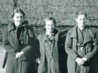 Black and white photo of three young women wearing coats
