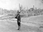 A National Guardsman stands on guard among the chimneys and foundations left after the Great Fire.