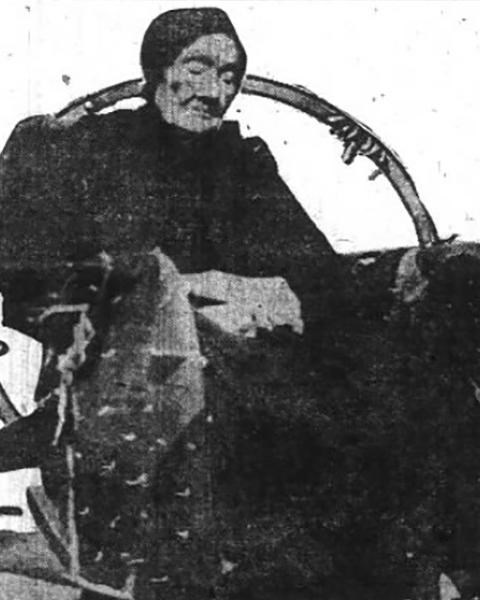 A black and white photo of an elderly woman in a rocking chair.