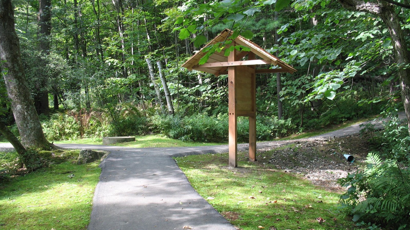 concrete path with wooden information kiosk