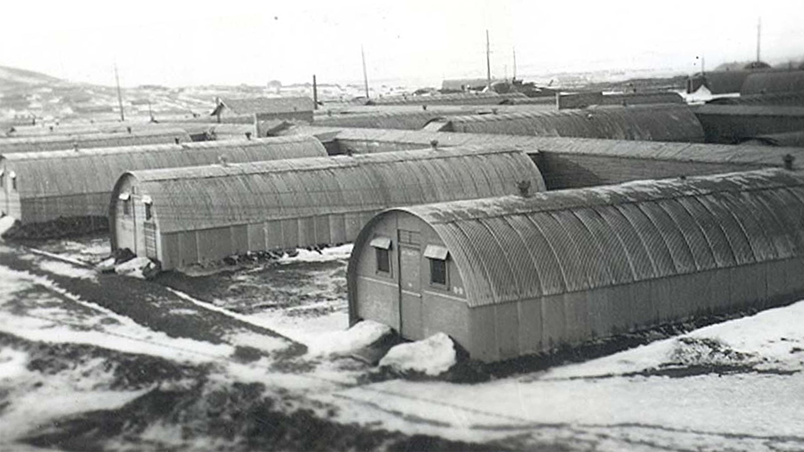 Historic photo of rows of long Quonset huts.