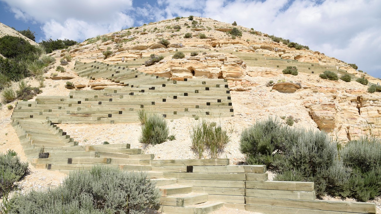 Several switchbacks of stairs lead up along the distinctive rock layers