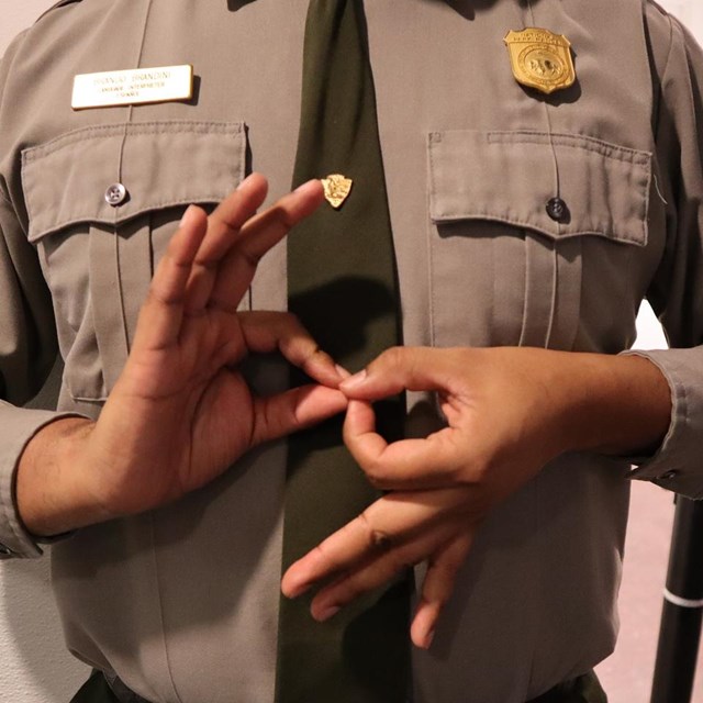 A ranger uses sign language.