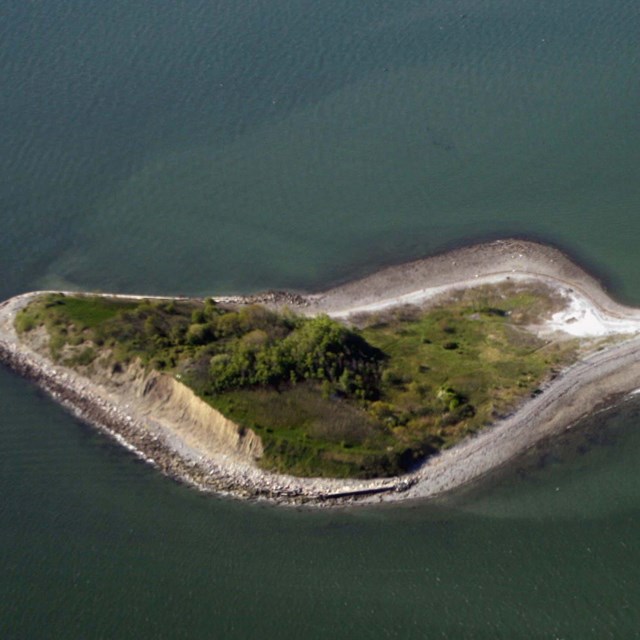 Aerial shot of an island composed of two triangles connected by a spit of land.
