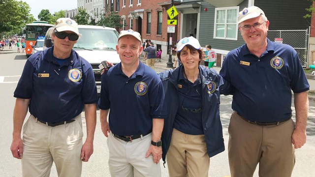 four middle-aged people wearing NPS volunteer navy shirts and ball caps