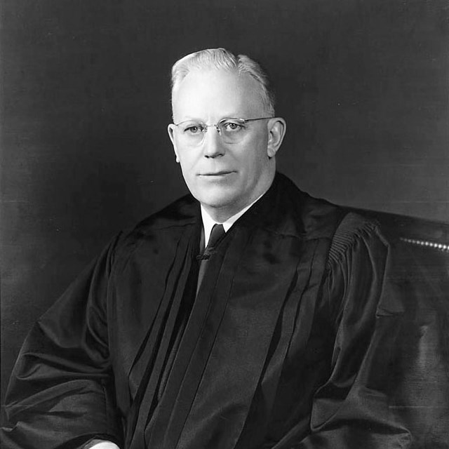 Earl Warren sits in his judicial robes.