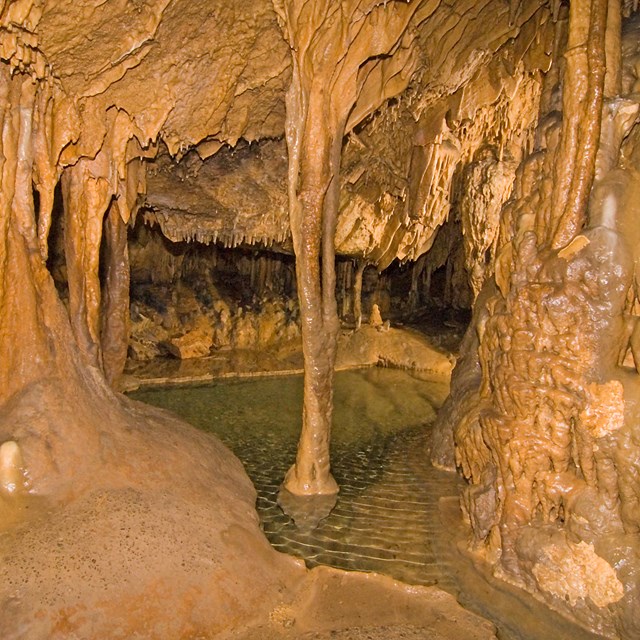 Cave formations above a pool of water