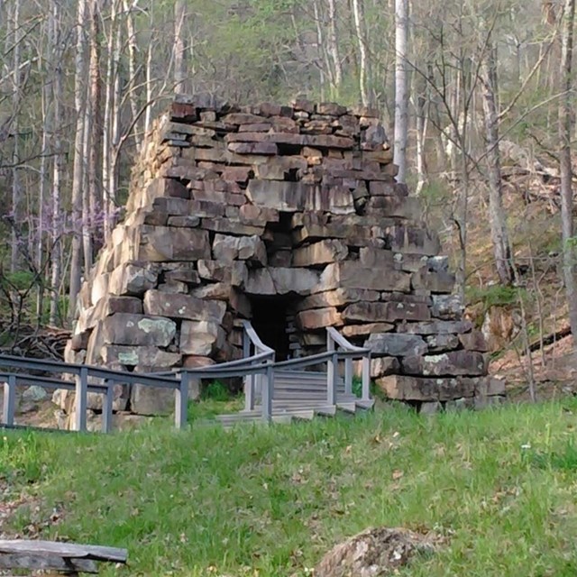 stone shaped pyramid structure with a door in the center and a walkway leading up.