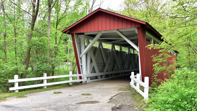 The red, covered bridge can be seen in this scenic spring photo.