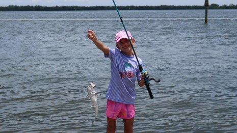 Young Girl holds fish she has caught