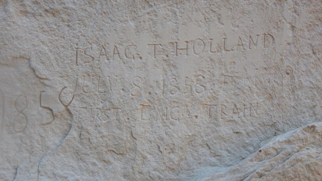 An inscription reading "Isaac. T. Holland July 8, 1858 First Emg. Train"