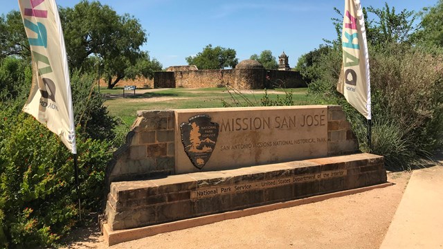 A stone entryway sign to a spanish-colonial style mission.