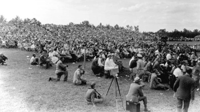 A large crowed sitting on a field during the dedication of Everglades National Park. 