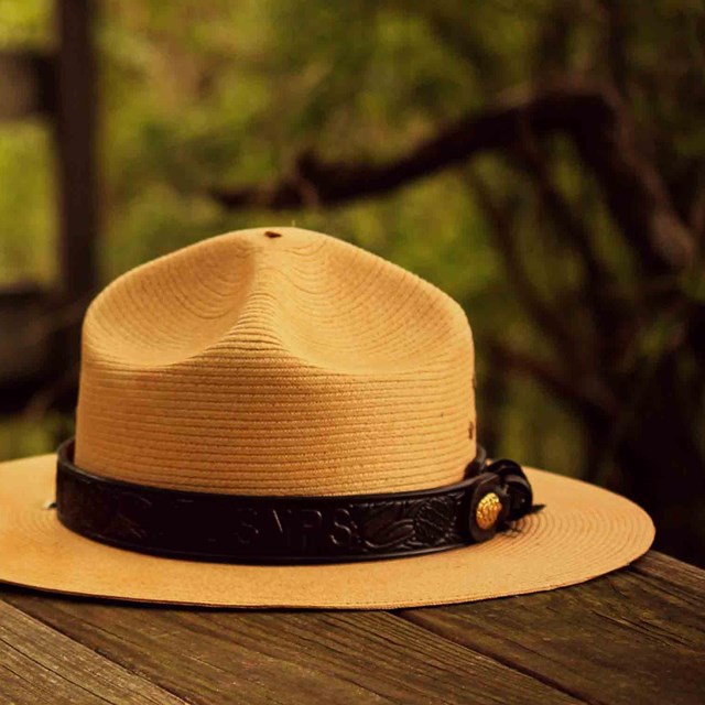 A summer park ranger hat on a wooden table.